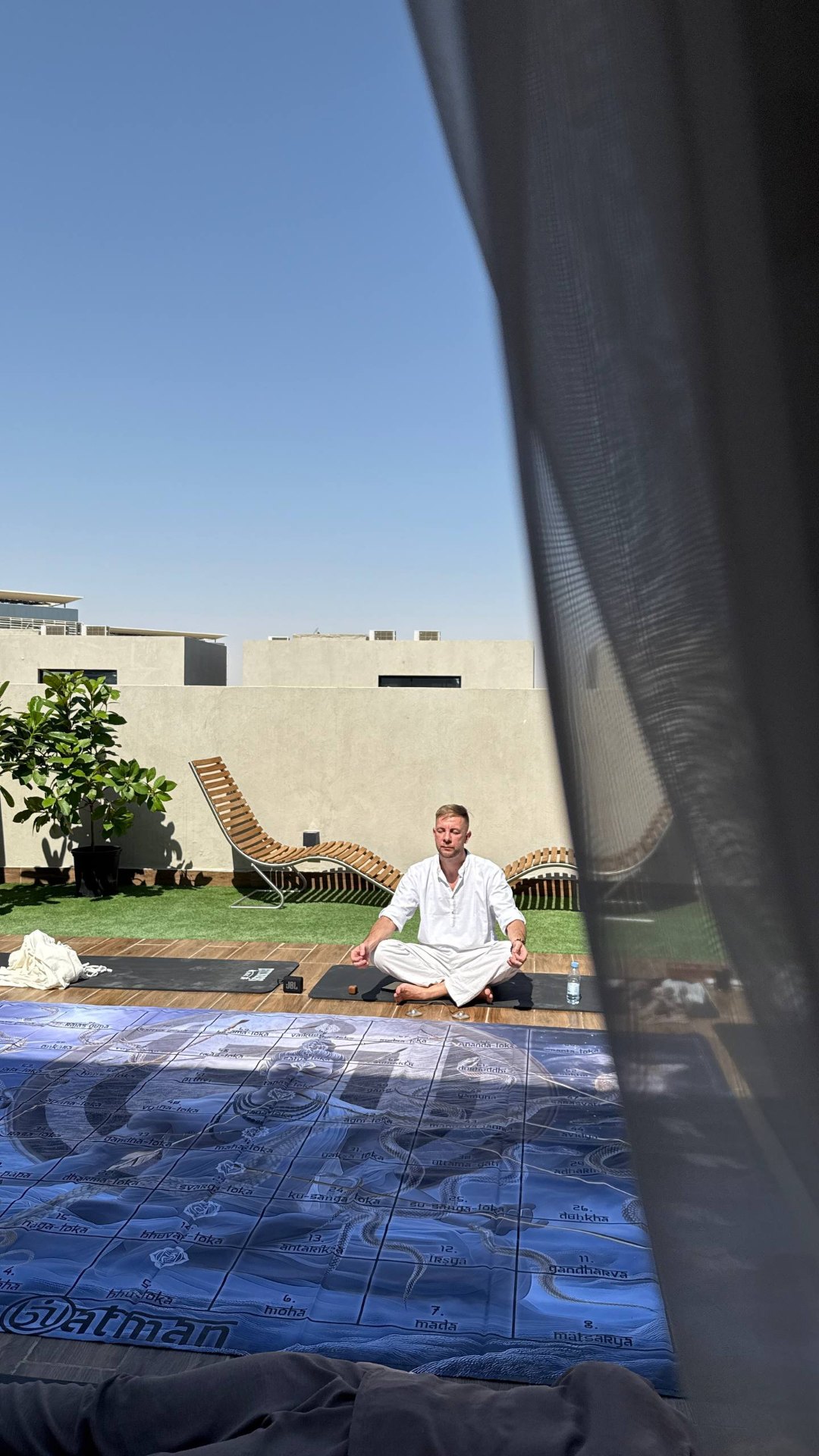 Anton in meditation on a Dubai rooftop beside the Leela board